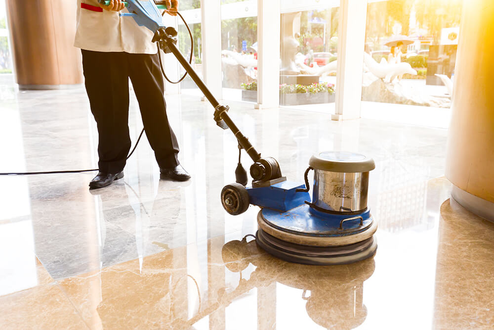 Cleaning man washing and polishing floor with machine in commercial building