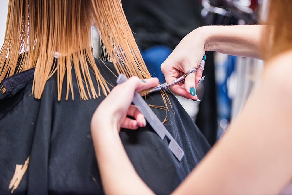 Woman getting a haircut by a hairstylist