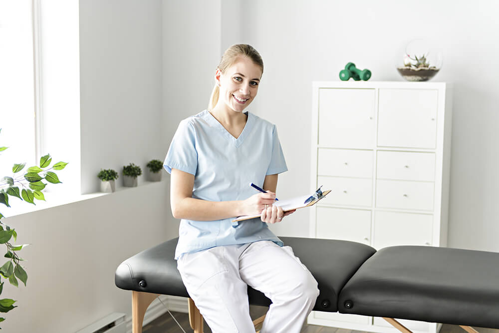 Woman physical therapist sitting on treatment board